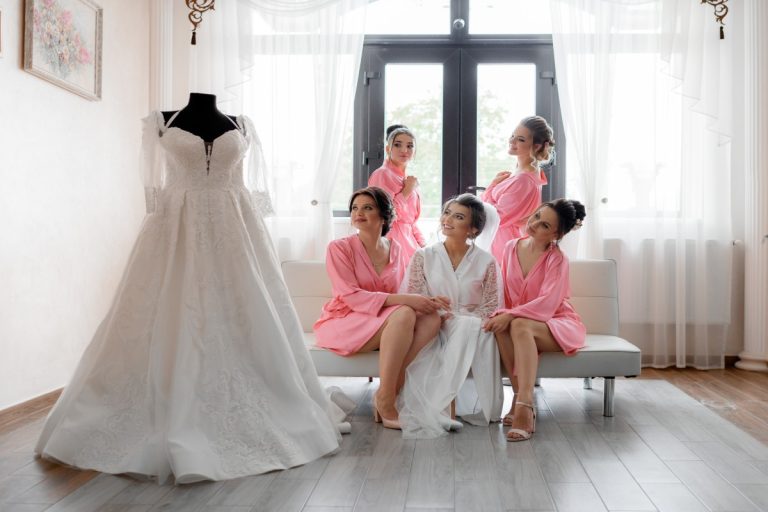 happy-smiled-bridesmaids-with-bride-is-looking-wedding-dress-light-room-wedding-preparation (1)